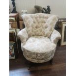 A VICTORIAN DESIGN REVOLVING ARMCHAIR Floral fabric upholstery, on turned legs with castors. (75cm x