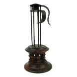A 19TH CENTURY PRIMITIVE IRON AND WOOD CANDLESTICK On a galleried spindled base. (27cm) Condition: