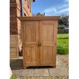 A VICTORIAN WAXED PINE DOUBLE WARDROBE With two panelled doors.