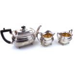 AN EDWARDIAN SILVER THREE PIECE TEA SERVICE Having ebonised wood finial, gadrooned border and gilt