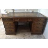 A REGENCY STYLE MAHOGANY PARTNERS DESK With green tooled leather top above an arrangement of nine
