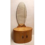 A STYLISH OVAL ART DECO OAK MIRRORED BACK DRESSING TABLE The cupboard doors opening to reveal shelf,