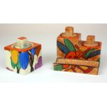 CLARICE CLIFF, AN EXTREMELY RARE POTTERY DOUBLE INKWELL IN BOBBINS Having two cubes of slightly