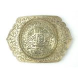 A PERSIAN WHITE METAL BUCKLE Having Islamic form inscription and engraved decoration. (approx 12cm)