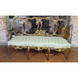 AN 18TH CENTURY ITALIAN WALNUT AND PARCEL GILT OPEN ARM CHAIR SETTEE With pierced strap work back