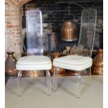 A PAIR OF VINTAGE AMERICAN LUCIDE AND FAUX CREAM LEATHER CHAIRS With bevelled lucite backs raised on