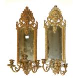 A PAIR OF BRASS GIRONDEL MIRRORS Cast with facial masks above shaped bevelled silver plates and