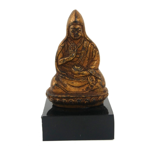 A CHINESE GILT BRONZE BUDDHA Seated pose holding an urn on black perspex base. (Buddha approx 6.7cm)