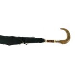 AN EDWARDIAN RHINOCEROS HORN HANDLED AND SILVER BANDED UMBRELLA. (90cm) Condition: overall good