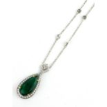 AN 18CT WHITE GOLD, EMERALD AND DIAMOND PENDANT NECKLACE The pear cut stone edged with round cut