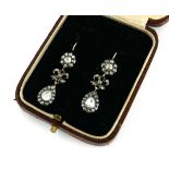 A PAIR OF YELLOW METAL AND ROSE CUT DIAMOND DROP EARRINGS Having two daisy cluster finials with pear