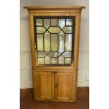 AN EARLY 19TH CENTURY PINE FLOOR STANDING CORNER CUPBOARD Having a single astragal glazed door above