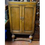 AN EARLY 20TH CENTURY OAK DRINK'S CABINET With two doors enclosing a fitted interior, complete
