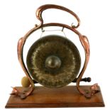 AN ART NOUVEAU PERIOD BEATEN COPPER TABLE DINNER GONG On an oak stand. (40cm x 36cm) Condition: good