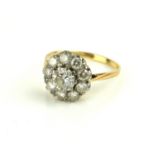 AN ART DECO YELLOW METAL AND DIAMOND CLUSTER RING The arrangement of round cut diamonds in a daisy