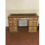 AN EARLY 20TH CENTURY OAK TWIN PEDESTAL DESK With red tooled leather top above an arrangement of