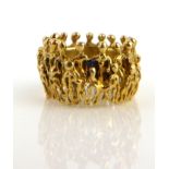 STUART DEVLIN, AN 18CT GOLD FIGURAL RING Having two layers of figures with children, marked to