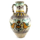 AN ANTIQUE PERSIAN TERRACOTTA EWER Twin handled and hand painted with a pair of exotic birds and