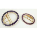 TWO EARLY 20TH CENTURY YELLOW METAL AND ENAMEL OVAL BUCKLES With purple enamel decoration. (larger