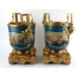 A PAIR OF CONTINENTAL DECORATED PORCELAIN URNS With gilt bronze mounts in the form of cherub masks