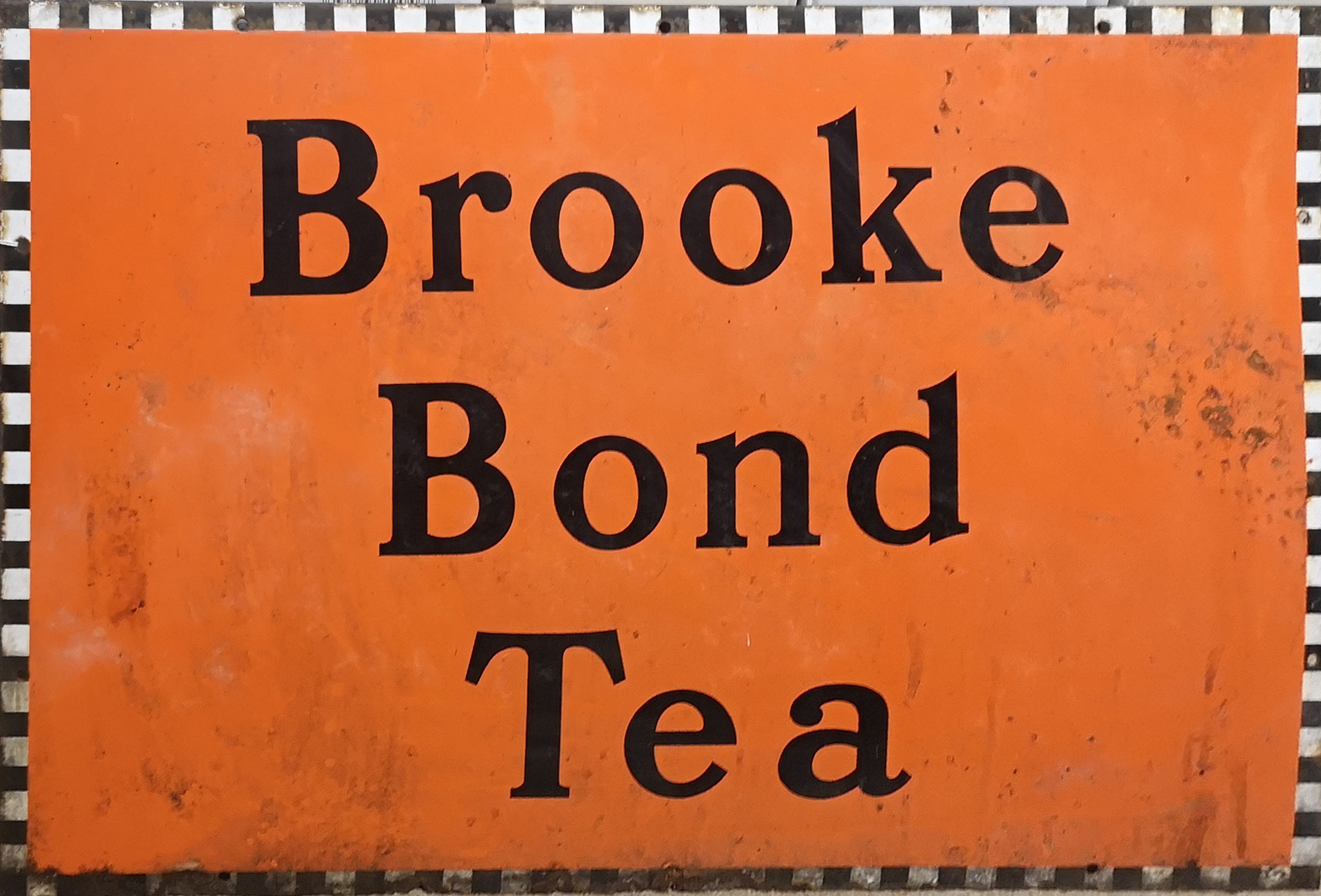 AN EARLY 20TH CENTURY ENAMEL 'BROOKE BOND TEA' RECTANGULAR ADVERTISING SIGN On an orange ground. (