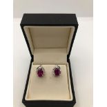 A PAIR OF 18CT WHITE GOLD, RUBY AND BAGUETTE AND BRILLIANT CUT DIAMOND EARRINGS, CIRCA 1970. (ruby