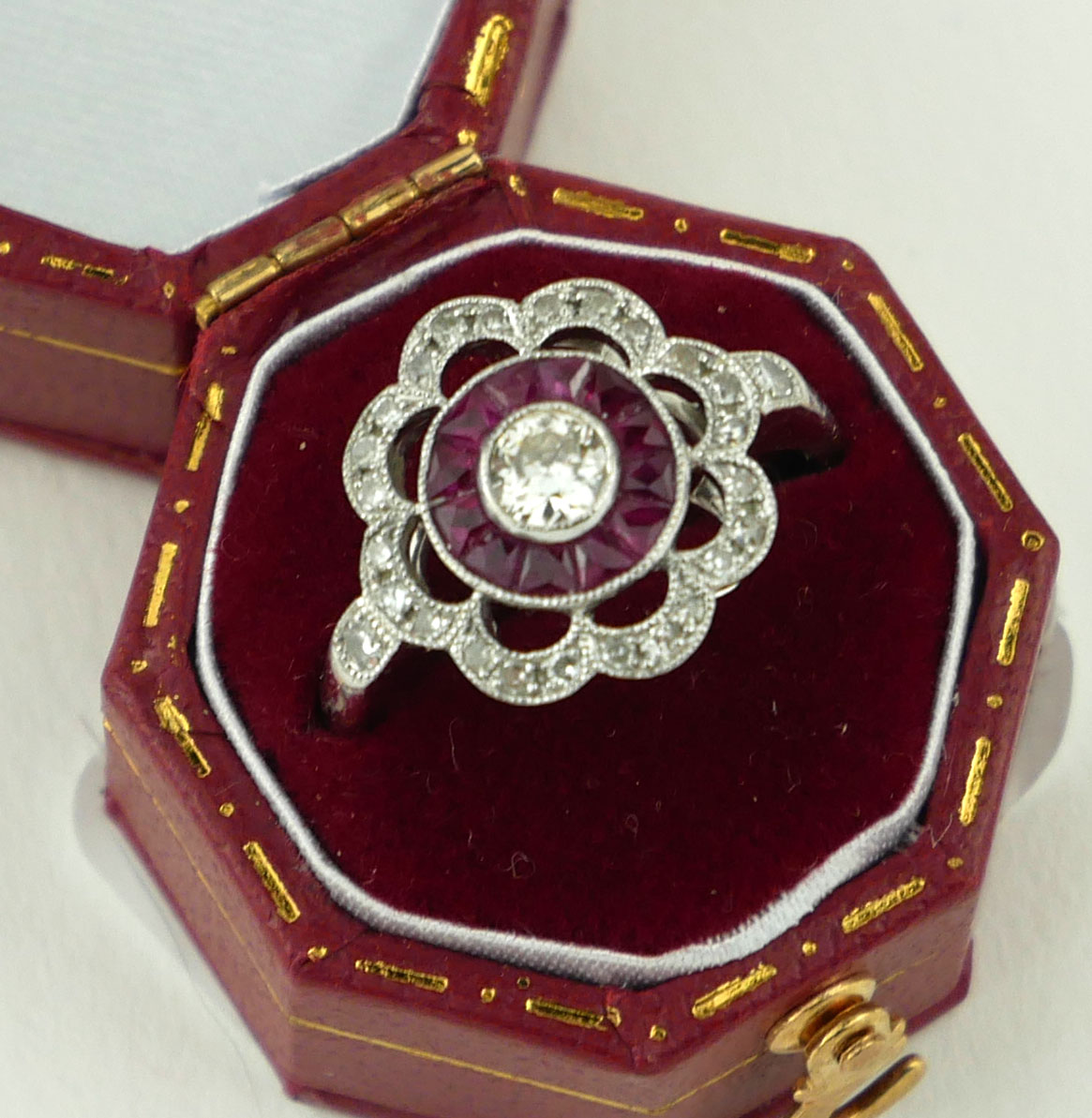 AN 18CT WHITE GOLD, RUBY AND DIAMOND FLOWER RING (size M½).