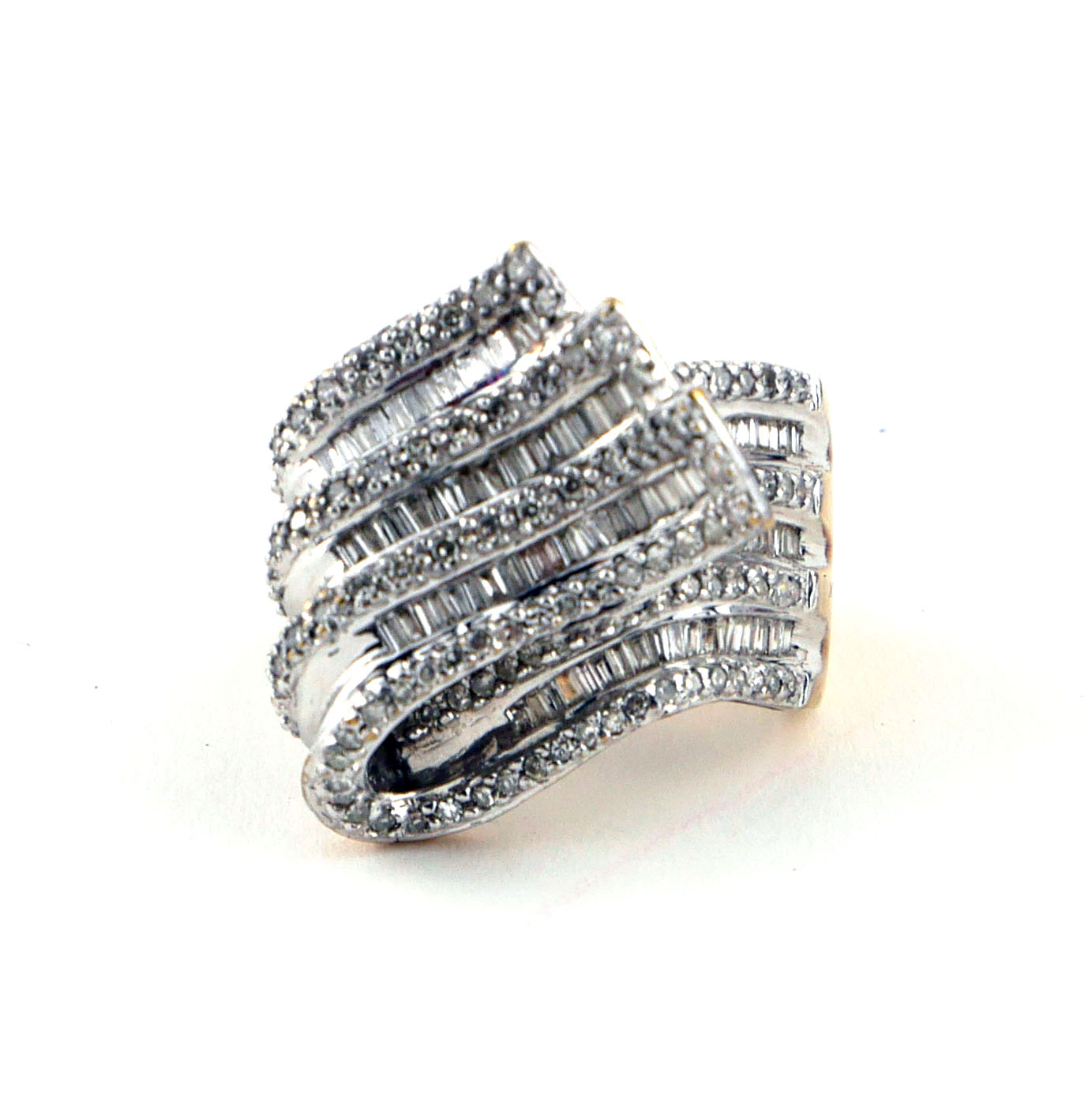 AN 18CT WHITE GOLD BAGUETTE CUT AND PAVÉ SET DIAMOND TWIRL RING, CIRCA 1970 (size L½).