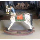 A CONTINENTAL CARVED WOODEN ROCKING HORSE Painted decoration. (67cm x 65cm) Condition: some losses
