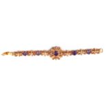A 22CT GOLD, AMETHYST AND SEED PEARL BRACELET Having a central oval cut amethyst in a pierced frame,