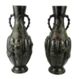 A PAIR OF 19TH CENTURY JAPANESE BRONZE VASES With faux bamboo handles above segmented bodies