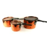 A SET OF THREE VICTORIAN COPPER SAUCEPANS Graduated form with circular lids and iron handles.