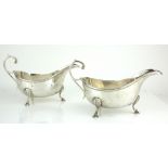 A PAIR OF EARLY 20TH CENTURY SILVER SAUCE BOATS Each having a single handle and shell form tripod