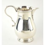 A FINE EARLY 20TH CENTURY BRITANNIA HALLMARKED SILVER BALUSTER CREAM JUG With Laaf capped scroll