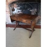 A REGENCY STYLE MAHOGANY SOFA TABLE With real and false drawers, raised on splayed legs joined by