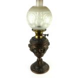 A 19TH CENTURY BRASS AND COPPER OIL LAMP With etched glass shade, detachable oil well and embossed