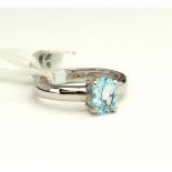 AN 18CT WHITE GOLD AND BLUE TOPAZ SOLITAIRE RING The oval cut pale blue topaz in a plain white