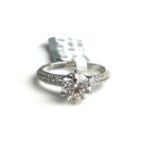 AN 18CT WHITE GOLD AND DIAMOND SOLITAIRE RING Flanked by diamonds shoulders (size M). (approx