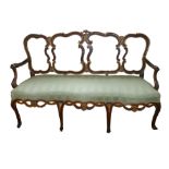 AN 18TH CENTURY ITALIAN WALNUT AND PARCEL GILT ARMCHAIR SETTEE With pierced strap work back and