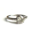 AN 18CT WHITE GOLD AND SOLITAIRE DIAMOND RING Flanked by diamond shoulders (size N/O). (approx total
