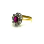 AN 18CT GOLD, RUBY AND DIAMOND CLUSTER RING The single oval cut ruby edged with round cut