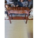 A 18TH CENTURY MAHOGANY FOLD OVER CARD TABLE Serpentine form with baize playing surface, on square