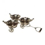A SILVER PLATED THREE BOTTLE WINE COASTER CART Each coaster having a scrolled border and cherubic