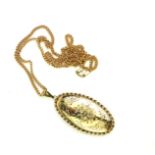 A 9CT GOLD PENDANT LOCKET AND NECKLACE Oval form with engraved decoration and fine chain