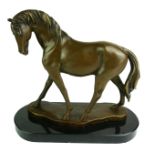 A 20TH CENTURY BRONZE MODEL OF A STANDING HORSE Raised on an oval black marble base. (h 30cm)