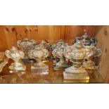 A COLLECTION OF NINE WHITE METAL CLASSICAL FORM MANTEL ORNAMENTS Cast as twin handled urns on carved