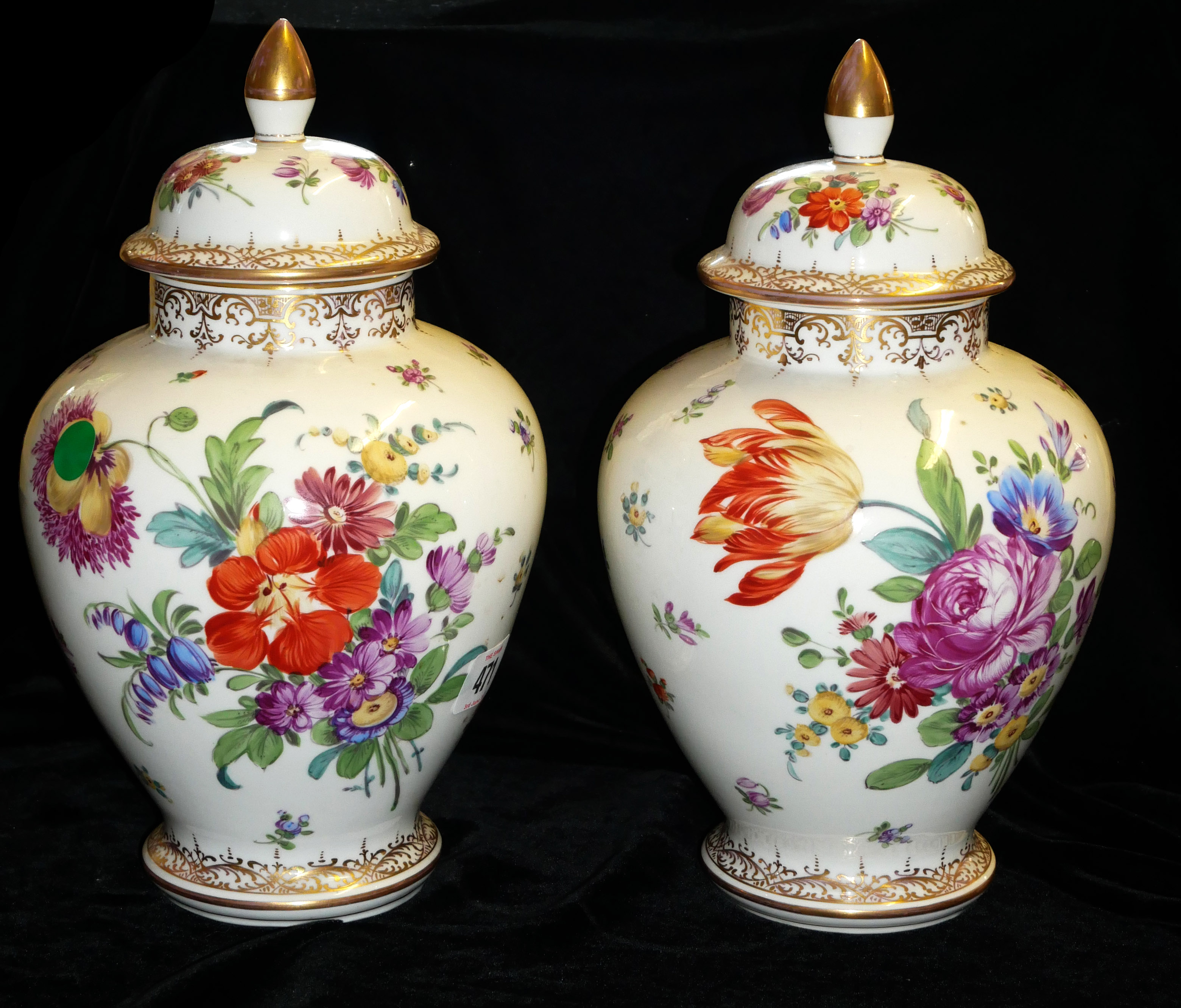 A PAIR OF DRESDEN VASES AND COVERS With floral decoration and gilt borders of organic form. (28cm)