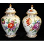 A PAIR OF DRESDEN VASES AND COVERS With floral decoration and gilt borders of organic form. (28cm)