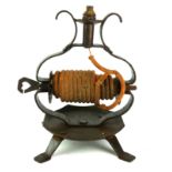 A 20TH CENTURY WROUGHT IRON WAX JACK Containing a wax coil candle and heart form handle. (approx