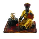 A COLD PAINTED BRONZE FIGURE OF AN ARAB Seated pose with hooker pipe and Persian design carpet. (